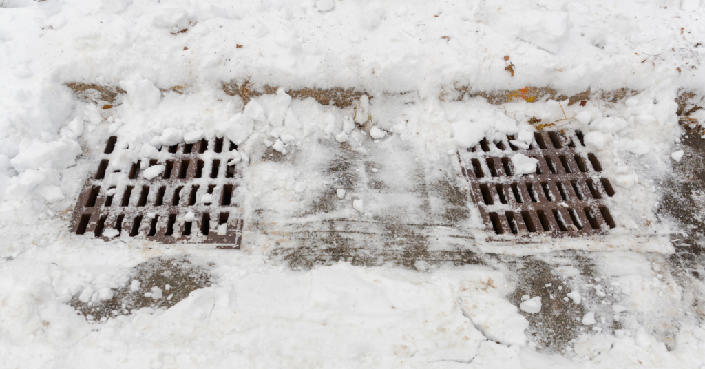 Stormwater drain covered in snow